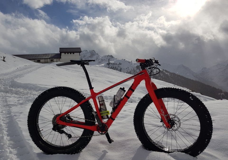 Fat bike rouge dans la neige, en montagne